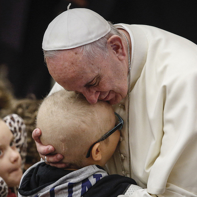 Papst Franziskus umarmt ein Kind während eines Treffens mit behinderten Menschen am 13. Januar 2016 im Vatikan.