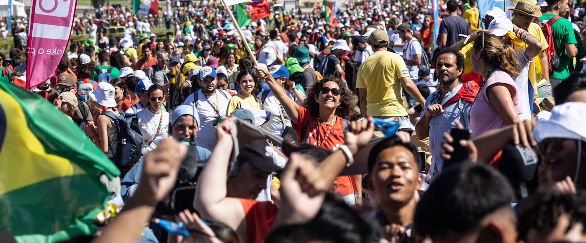 Junge Menschen schwenken Fahnen im Parque Eduardo VII vor der Eröffnungsmesse des WJT in Lissabon (Portugal) am 1. August 2023.