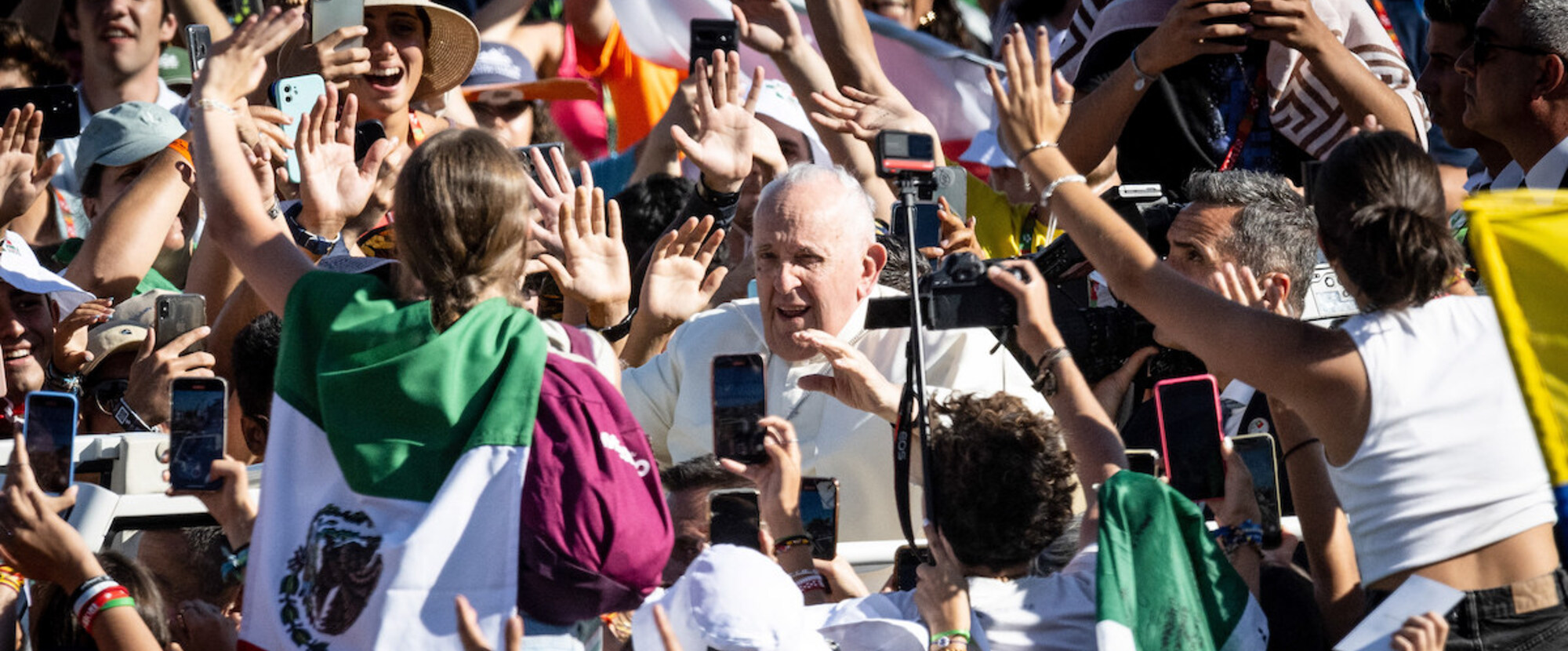 Papst Franziskus grüßt die Menschen, während er im Papamobil zum Kreuzweg auf dem Weltjugendtag in den Parque Eduardo VII. fährt, am 4. August 2023 in Lissabon (Portugal).